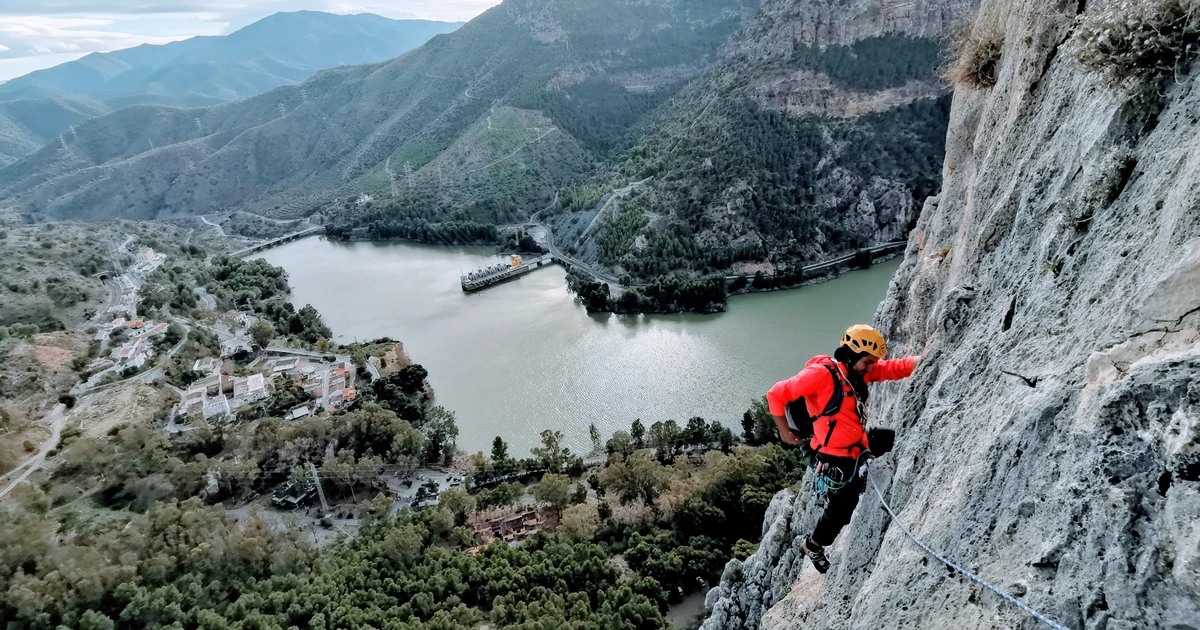 Rock climber on a limestone wall above the Guadalhorce reservoir in El Chorro, Málaga